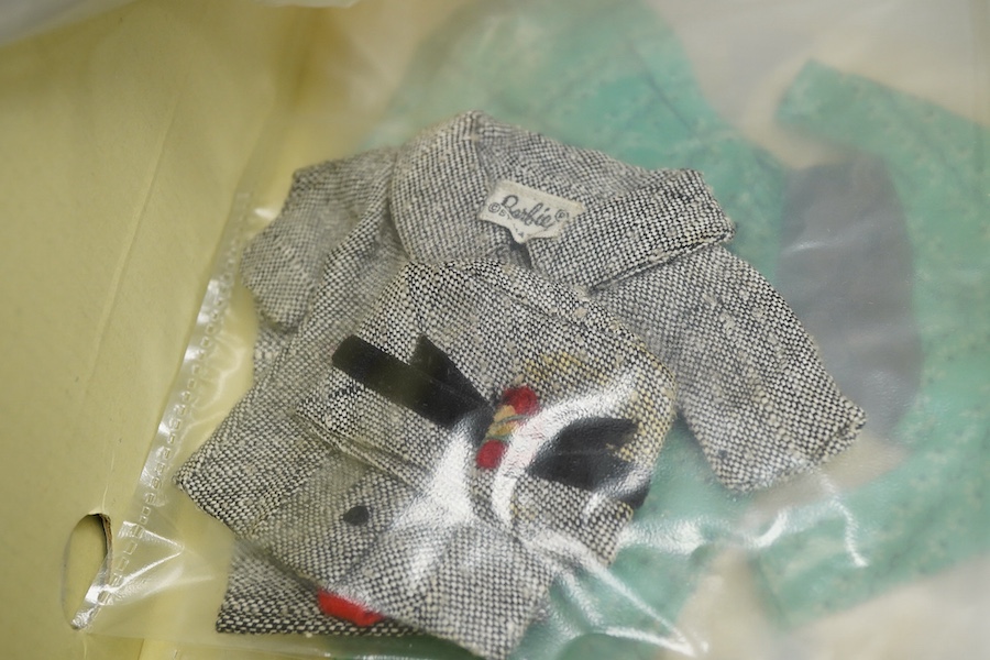 A 1960's Mattel Inc. Barbie doll, 1963, together with a Skipper doll, and a collection of eight original outfits with accessories, sorted into individual packets, outfits purchased between 1963 to 1966 include; American